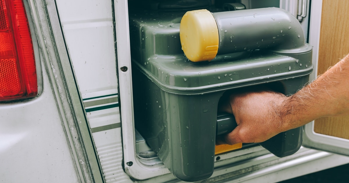 A close-up shows a person pulling a dark-green holding tank from a vehicle. The tank has water droplets on it.