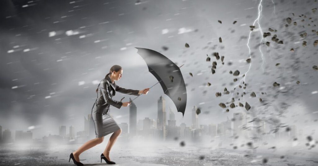 A businesswoman braces with an umbrella against high winds as rain, debris, and lightning surge around a city skyline.